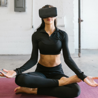 Young woman in lotus position wearing virtual reality glasses
